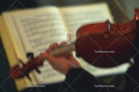 عکس با کیفیت نوازنده در حال نواختن ویولن با نت موسیقی 